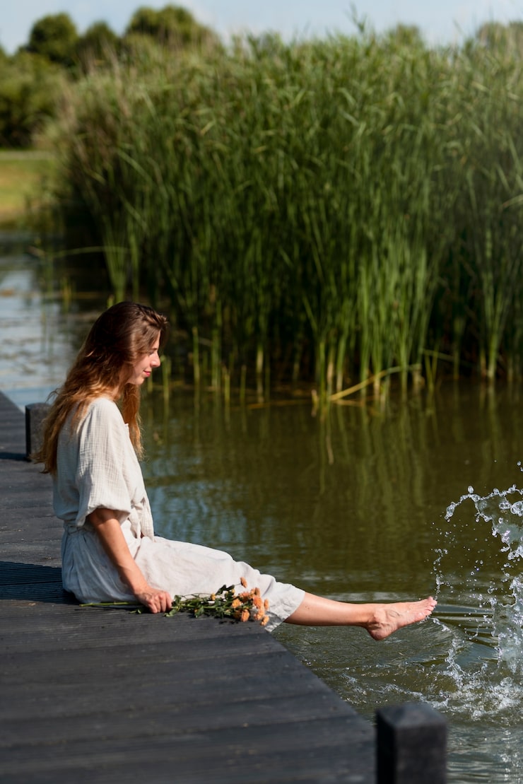 woman-sitting-by-lake-full-shot_23-2149513249